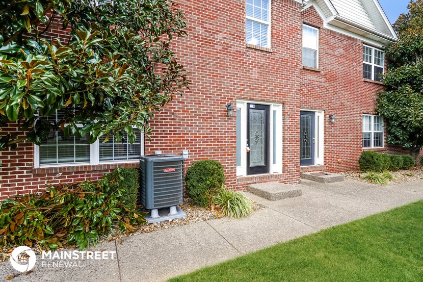 a side view of a brick house with a mailbox in front