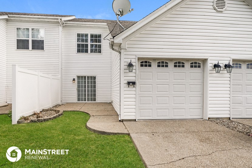 a white house with a white garage door and a lawn