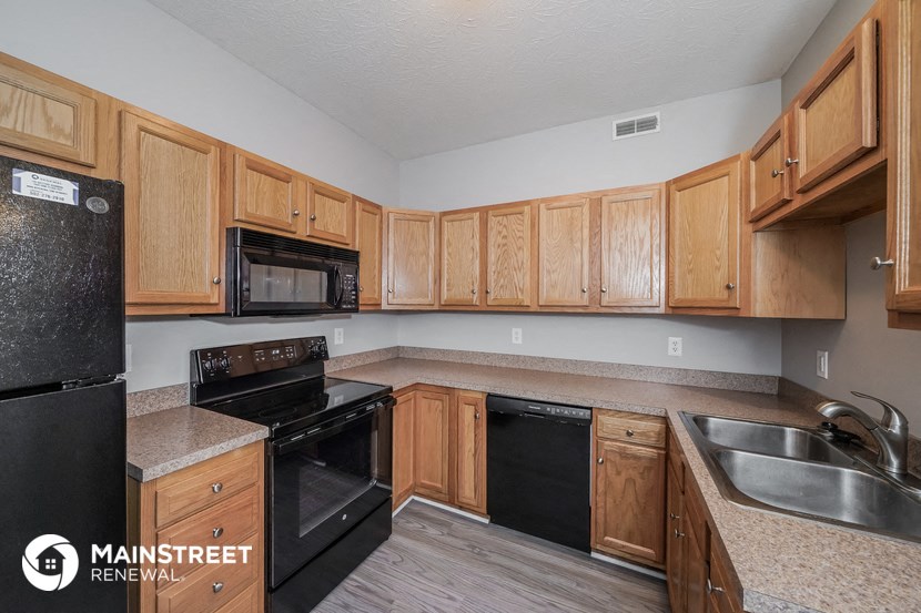 a kitchen with wood cabinets and black appliances