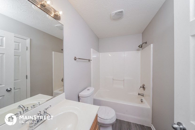 a white bathroom with a tub and a sink and a toilet
