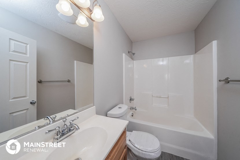 a bathroom with a white tub and a sink and a toilet