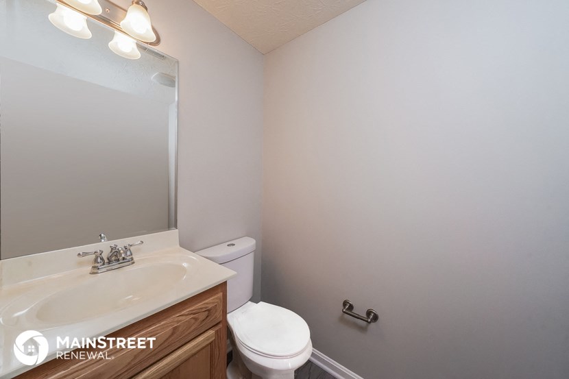 a bathroom with a toilet and a sink and a mirror