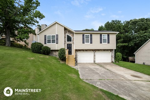 a beige house with a driveway and a garage door