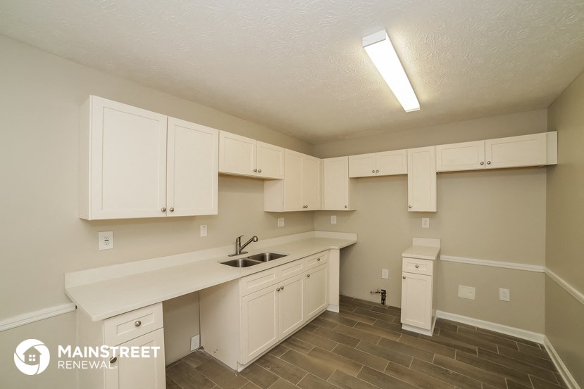 a kitchen with white cabinets and a sink and a counter