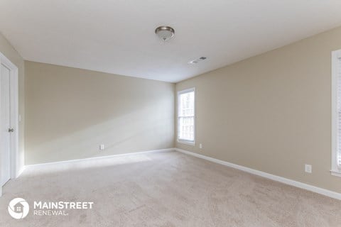 the spacious living room with white carpet and white walls