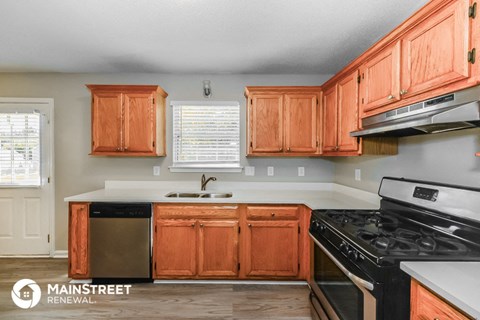 a kitchen with wooden cabinets and a stove and a sink