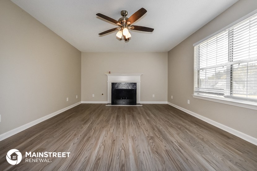 the living room with wood flooring and a fireplace