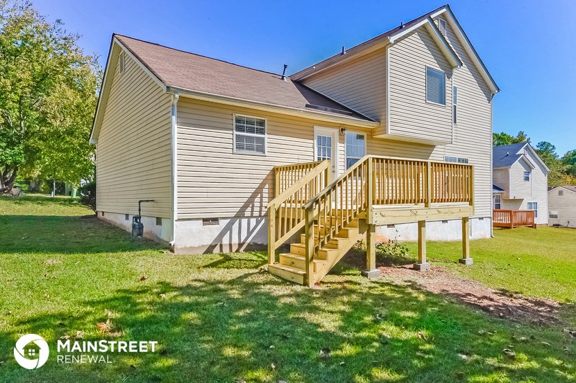 the back of a house with a wooden porch and stairs