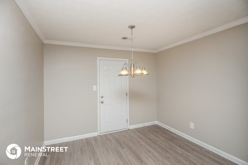the spacious living room with a door to the dining room