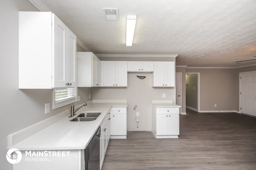 an empty kitchen with white cabinets and a sink