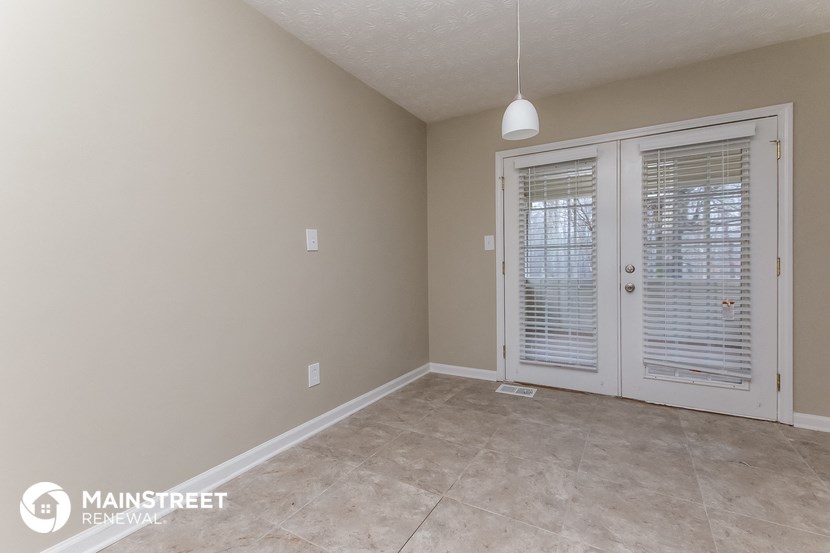 an empty living room with a door to a patio