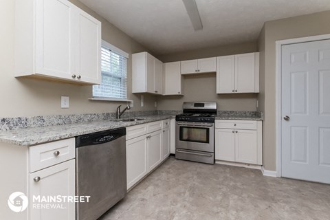 a large kitchen with white cabinets and stainless steel appliances
