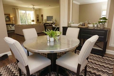a dining room with white chairs and a table