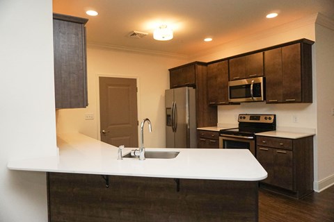 A kitchen with brown cabinets and white countertop.