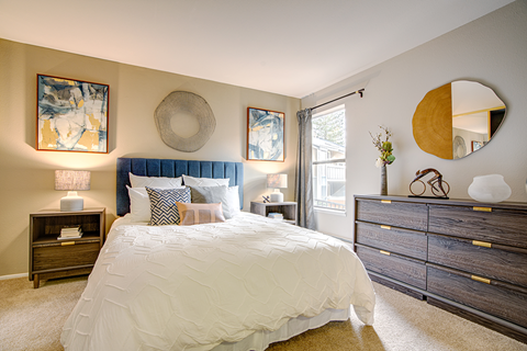 A bedroom with a large bed and a mirror on the wall.