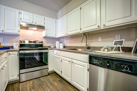 A kitchen with white cabinets and stainless steel appliances.