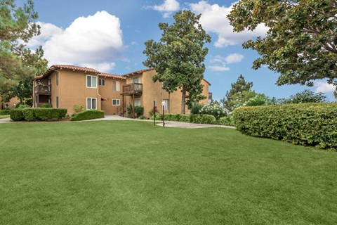 a large green lawn in front of an apartment building
