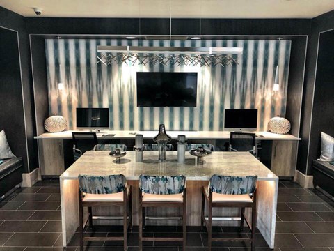 A modern kitchen with a marble table and striped wallpaper.