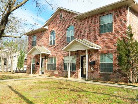 a brick house with a yard in front of it