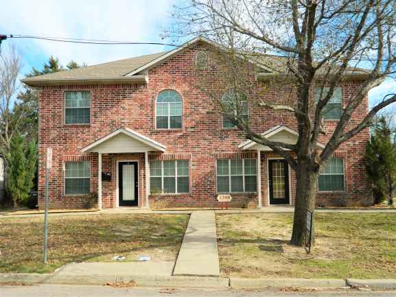a brick house with a tree in front of it