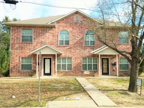 a brick house with a sidewalk in front of it