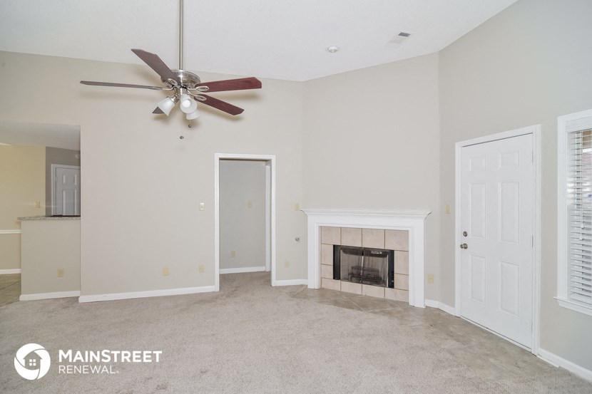 the living room with fireplace and ceiling fan