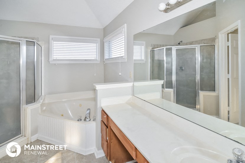 a bathroom with a large tub and a sink and a mirror