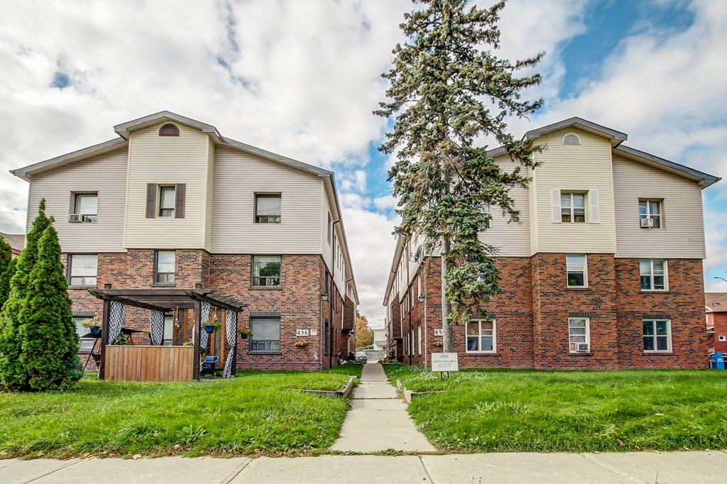 A row of houses with a sidewalk in between.