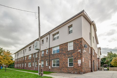 A large brick building with a grey roof and multiple windows.