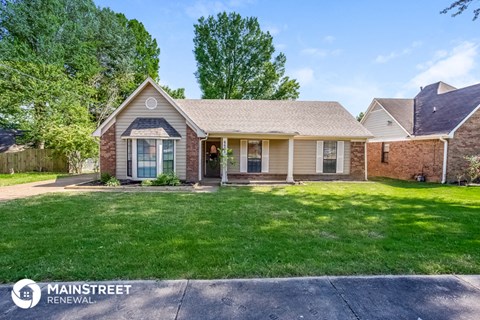 a small brick house with a lawn in front of it