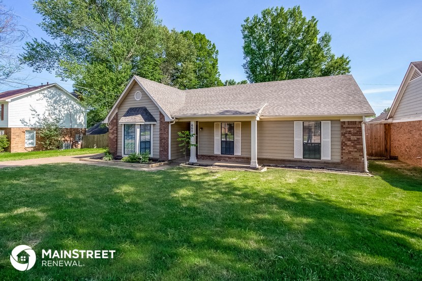 the front of a house with a yard and grass
