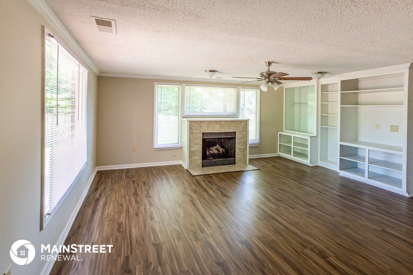 a living room with wood floors and a fireplace