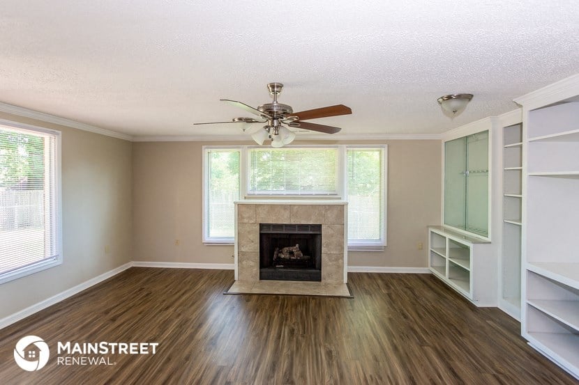 a living room with a fireplace and a ceiling fan