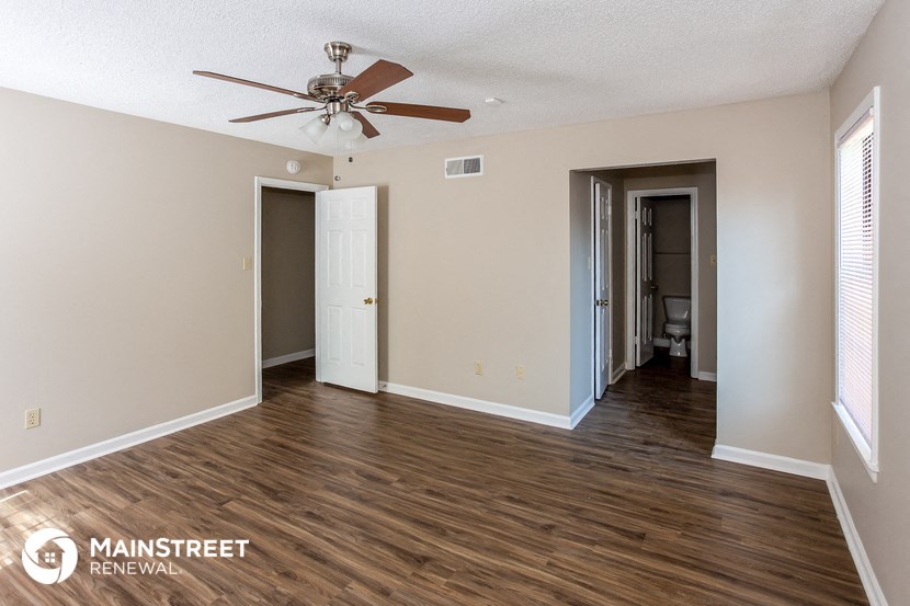 a living room with hardwood floors and a ceiling fan