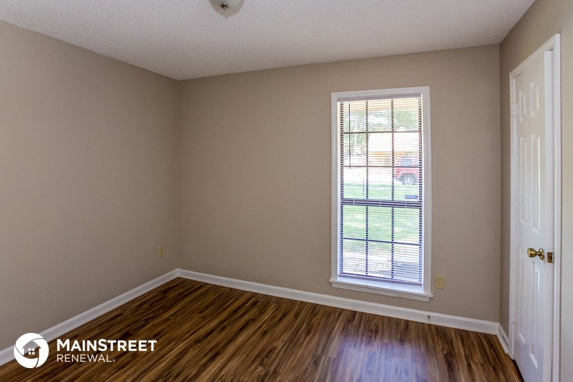 the interior of an empty room with wooden floors and a window