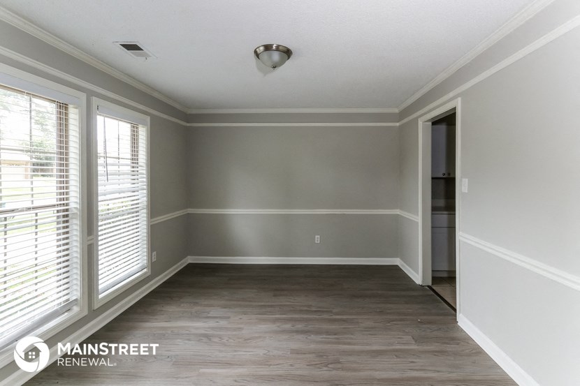 the living room of a new home with grey walls and white trim