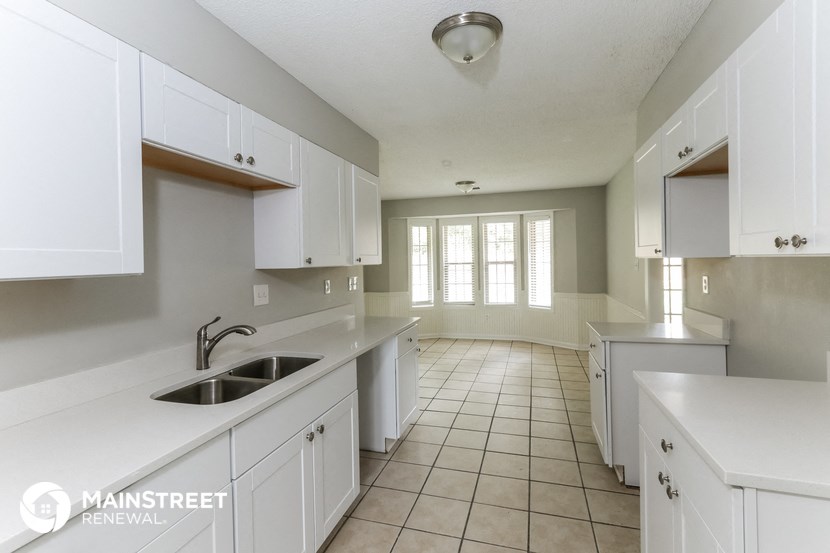 a large white kitchen with white cabinets and a sink