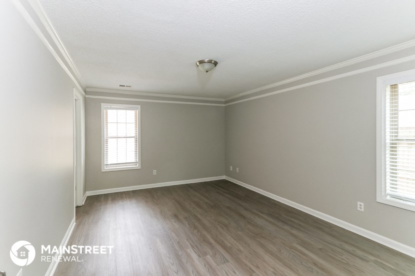 the living room of a new home with wooden floors and grey walls
