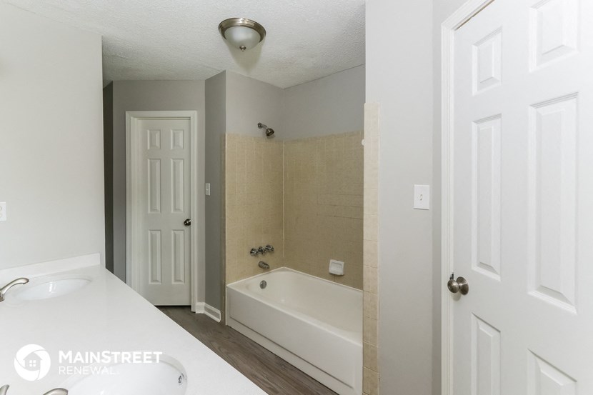 a white bathroom with a tub and a sink