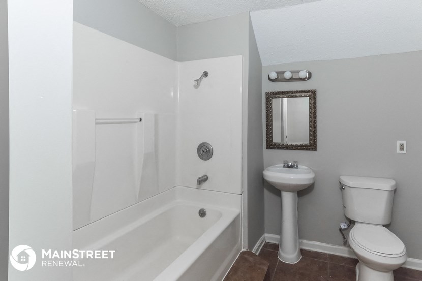 a white bathroom with a toilet sink and a shower