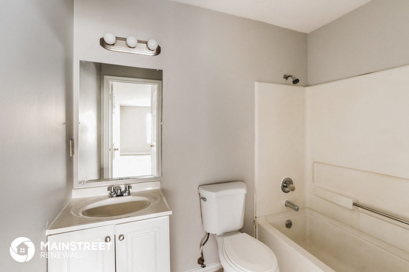 a bathroom with a toilet sink and tub and a mirror