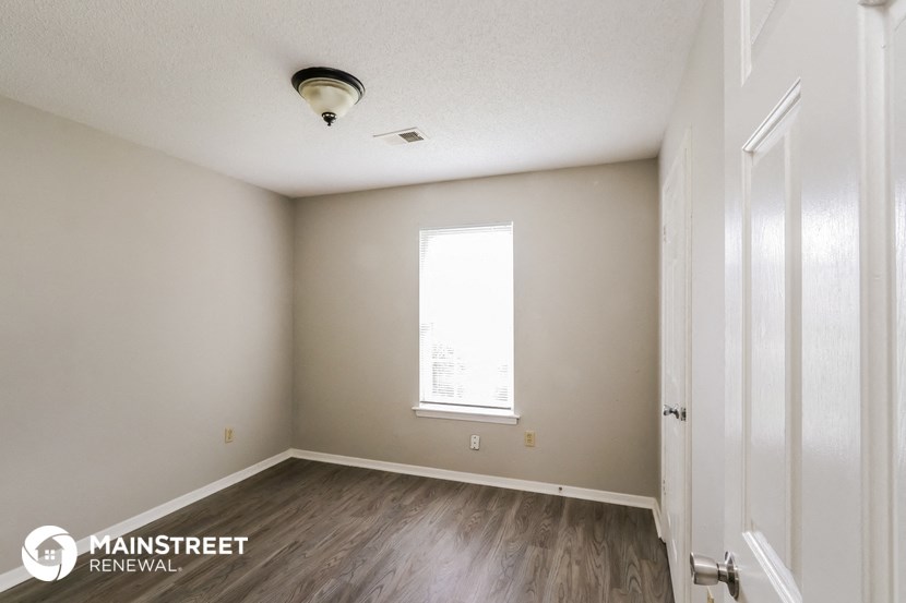the interior of an empty room with wooden floors and a window
