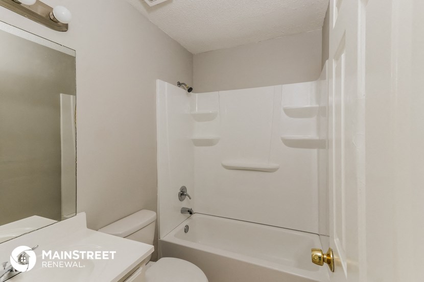 a bathroom with a shower and a toilet and a sink