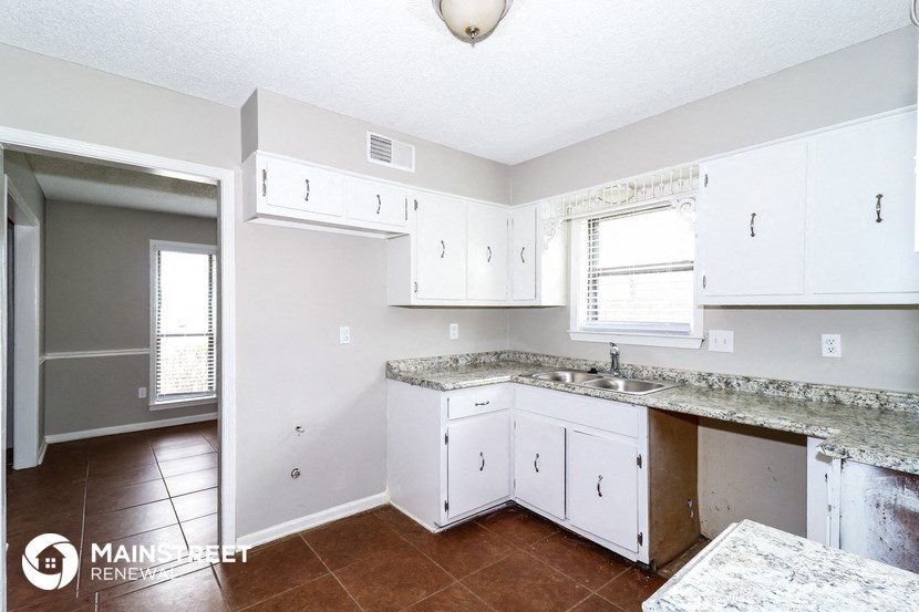 a kitchen with white cabinets and a counter top and a sink
