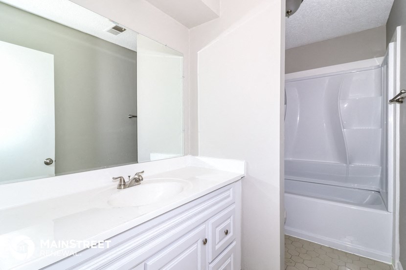 a bathroom with a sink and a shower and a mirror
