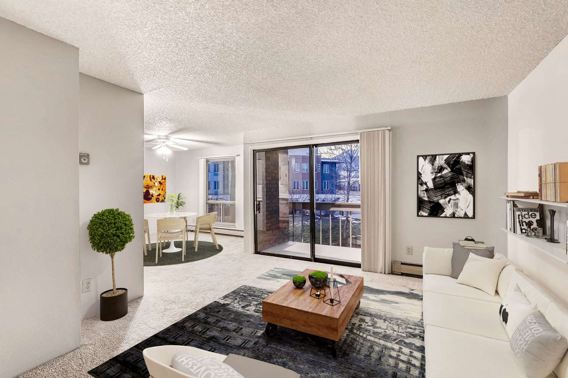 a living room with a white couch and a coffee table and a sliding glass door