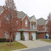 a house with three garages and a tree in front of it