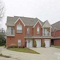 the front of a brick house with three garage doors