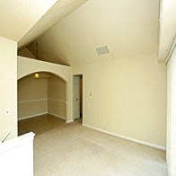 an empty living room with a vaulted ceiling