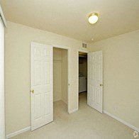 an empty bedroom with two doors and a closet
